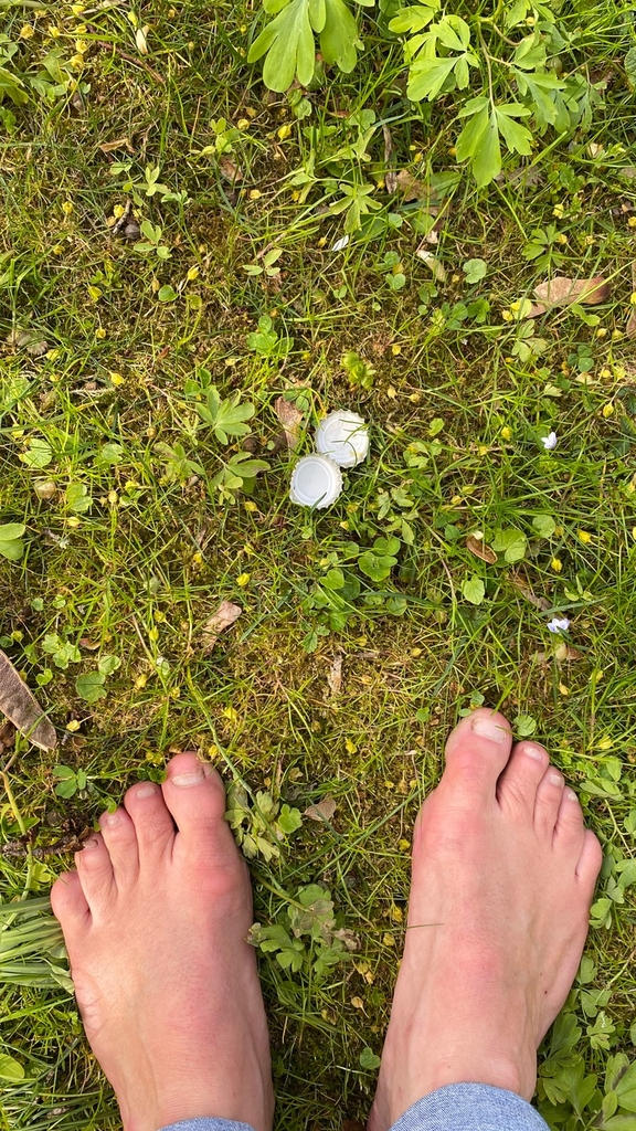Barfuß und Kronkorken auf einer Wiese