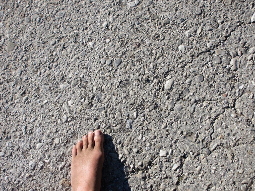 Barfuß auf grobem Asphalt