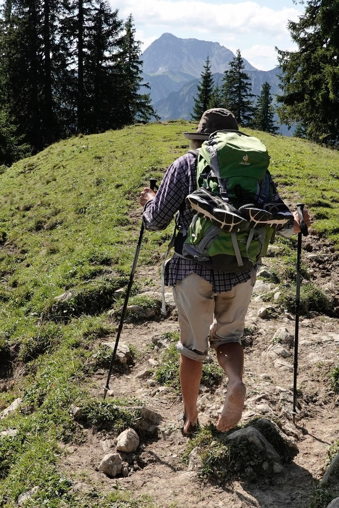 Eine ältere Dame geht barfuß über die Berge