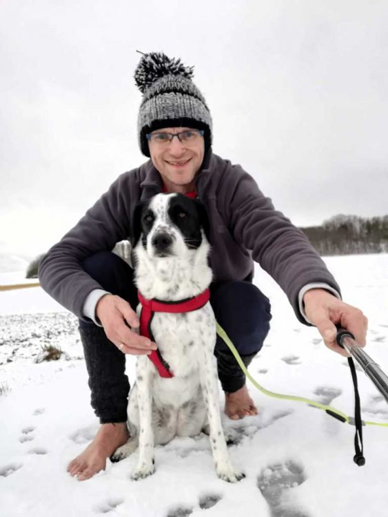 Jürgen Hirsch barfuß und mit Hund im Schnee